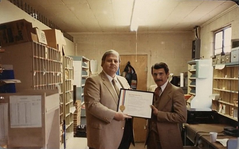 Ken Belden receiving a postal service award